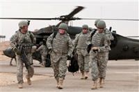 Army Command Sgt. Maj. Lawrence Wilson accompanies Army Sgt. 1st Class Mike Schlitz, a wounded warrior returning to Iraq as part of Operation Proper Exit, Dec. 29, 2009, at Camp Ramadi, Iraq. The program returns severely wounded veterans to the battlefield where they were wounded to help them find psychological closure. U.S. Army photo by Spc. Michael J. MacLeod