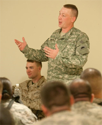 Retired Staff Sgt. Luke Wilson jokes that audience members can play with his prosthetic leg if they want to during a